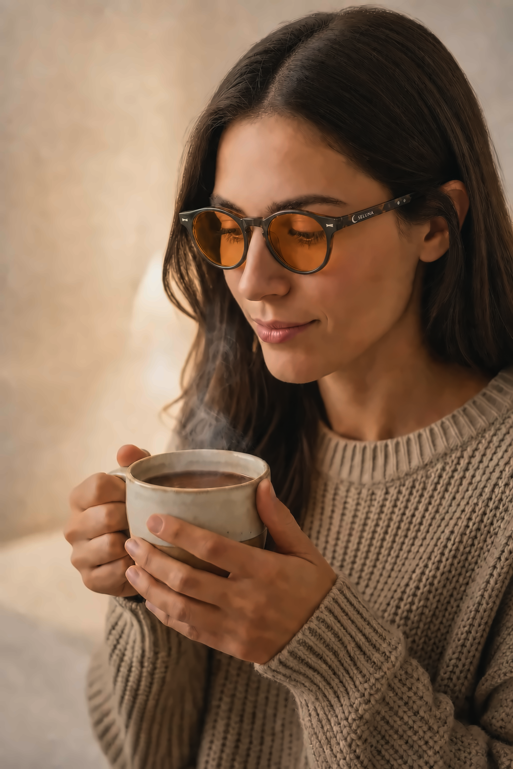 Woman in amber evening glasses sipping cocoa
